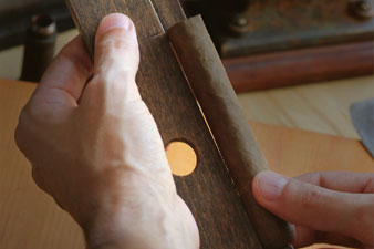 Das Bild zeigt eine Hand beim Messen der Größe einer kubanischen Habano Zigarre.